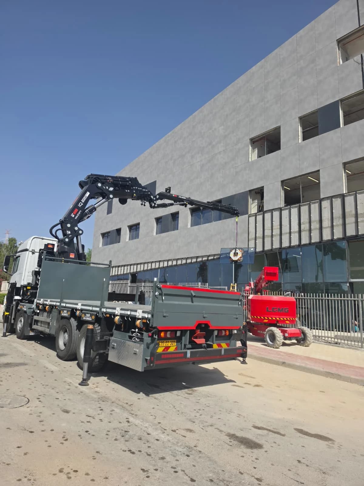 משאית מנוף של ברק שאוקתי לצד מבנה