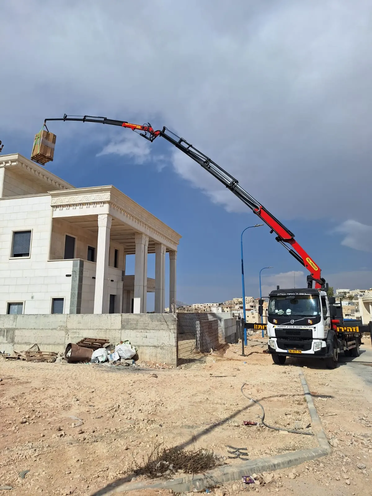 משאית מנוף מניפה מטען באתר בנייה